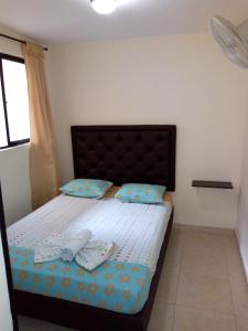 a bedroom with a bed with two shoes on it at Hotel T&aacute;chiras in Bucaramanga
