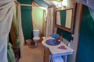 a small bathroom with a sink and a toilet at Sahara Desert Luxury Camp in Merzouga +37 photos