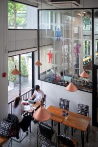 two people sitting at tables in a restaurant at Yaks House Hostel - SHA Plus in Bangkok