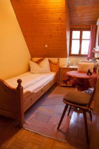 a bedroom with a bed and a desk and a chair at Pension Elke Rothenburg in Rothenburg ob der Tauber