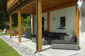 un patio cubierto con sofás y una mesa en Villa Vicana, en Kirchbach