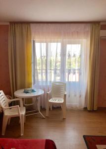 a living room with a table and chairs and a window at Hotel Elion in Zatoka