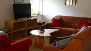 een woonkamer met 2 banken en een televisie bij Ferienwohnung Gisela in Bausendorf