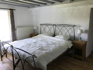a bedroom with a large bed with white sheets at Ferme du Grand Frêne in Naomé +25 photos