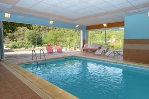 uma piscina numa casa com uma grande janela em Logis Hôtels - Hostellerie des Lauriers - Hôtel et Restaurant em Alban
