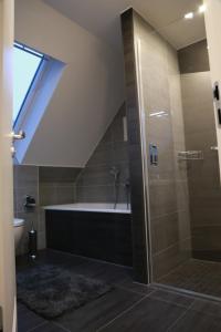 a bathroom with a shower and a bath tub at Wohnkomfort wie Zuhause in Neubrandenburg +14 photos