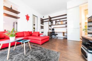 un soggiorno con divano rosso e tavolo di Life Apartment & City Bike a Bolzano