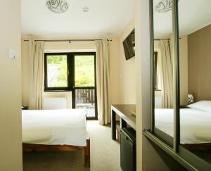 ロンデク・ズドルイにあるPensjonat Trojakのベッド2台と鏡が備わるホテルルームです。
