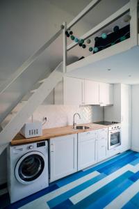 a kitchen with a washing machine and a staircase at Pause Apartment with Free Parking in Budapest