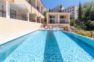 ein Schwimmbad in der Mitte eines Gebäudes in der Unterkunft Résidence d'Azur Riou in Cannes