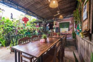 a restaurant with a long wooden table and chairs at UNCLE'S HOUSE, Siem Reap in Siem Reap