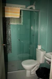 ein Badezimmer mit Toilette und Glasdusche in der Unterkunft Nossa casa em Canela in Canela + 13 Fotos