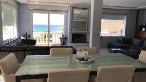 a living room with a table and chairs and the ocean at Villa Tanger Cap Spartel in Tangier