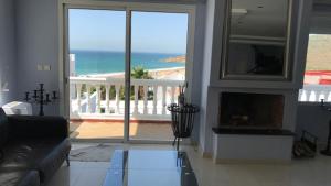 a living room with a fireplace and a view of the ocean at Villa Tanger Cap Spartel in Tangier