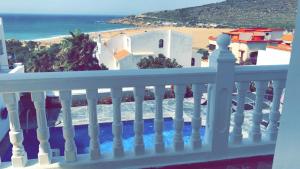uma varanda branca com vista para a praia em Villa Tanger Cap Spartel em Tânger