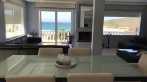 a living room with a table and a view of the ocean at Villa Tanger Cap Spartel in Tangier