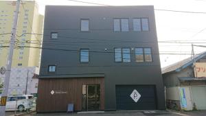 un edificio gris con una puerta delante en Guest House Proof Point, en Kushiro