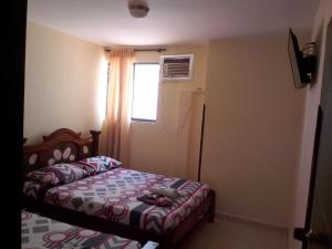 a small bedroom with a bed and a window at Hotel Táchiras in Bucaramanga