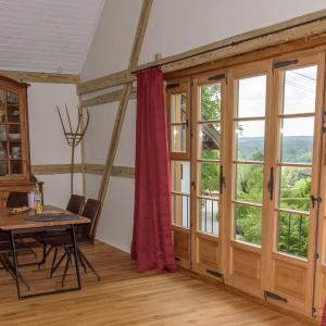 ein Esszimmer mit großen Fenstern und einem Tisch in der Unterkunft Chalet Landsberg in Landsberg am Lech