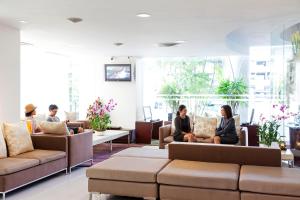 a group of people sitting on couches in a lobby at Viva Garden Serviced Residence in Bangkok