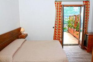 ヴィーコ・エクエンセにあるVilla Rosa di Nonna Rosaのベッドルーム1室(ベッド1台付)、バルコニーへのドアが備わります。