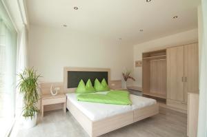 - une chambre avec un lit doté d'oreillers verts dans l'établissement Weinreichhof, à Castelbello