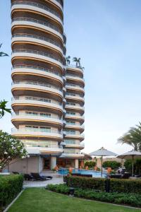 a tall building with a pool in front of it at Viva Garden Serviced Residence in Bangkok