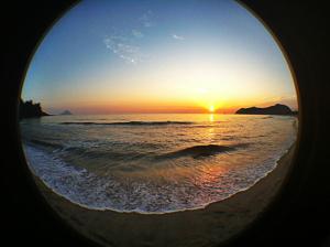 a view of a beach with the sun setting at Aparthotel Barracuda in Ponta Delgada
