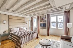 une chambre d'hôtel avec un lit et un canapé dans l'établissement Luxury Apartment Paris Louvre, à Paris