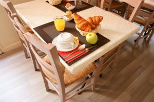 a table with a breakfast of croissants and orange juice at Central Hotel in Niort
