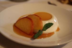 une assiette blanche avec dessert à la sauce et aux pommes dans l'établissement Country House Torrenera, à Morro dʼOro