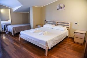 una camera da letto con un letto con due asciugamani sopra di Attic Aries a Montesilvano