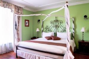 ein Schlafzimmer mit einem weißen Bett mit Baldachin in der Unterkunft Casa Aliso Hotel Boutique in Quito