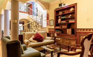 a living room with two couches and a book shelf at Casa Aliso Hotel Boutique in Quito