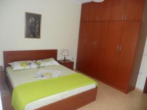 a bedroom with a bed and wooden cabinets at Villa Braho 1 in Pogradec