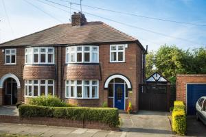 ein rotes Backsteinhaus mit einer blauen Tür in der Unterkunft City Apartments - 4 Heworth Village - 3 bed house in York