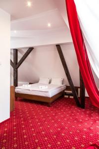 a bedroom with a bed and a red carpet at Fregata in Ełk