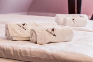 a white towel laying on top of a white bed at Fregata in Ełk