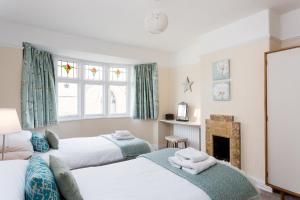 1 dormitorio con 2 camas y chimenea en City Apartments - 4 Heworth Village - 3 bed house, en York