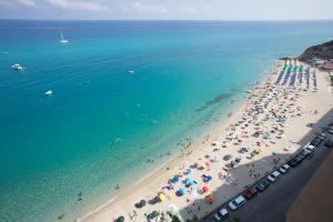 - une vue sur une plage avec des personnes et des parasols dans l'établissement Il Duca, à Tropea