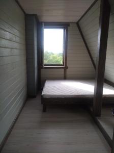an attic room with a bed and a window at Нарочанская хатка 2 in Narochʼ