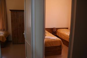 a bedroom with two beds and a door to a room at Lucytour Hotel in Hermon