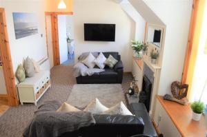 a living room with a couch and a tv at Flat 14c Bayhead in Stornoway