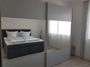 a bedroom with a bed with a mirrored wall at Moderne Neubau Ferienwohnung in Kassel