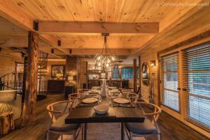 a dining room with a long table and chairs at Chalet TAO par Les Chalets Spa Canada in La Malbaie