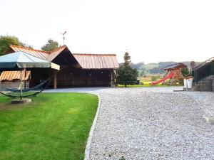a gravel driveway next to a barn and a playground at Gościniec Na Brzyzku in Białka Tatrzańska