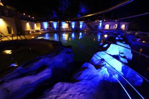 a swimming pool lit up at night with blue lights at Hotel Villa Margherita in Quercianella
