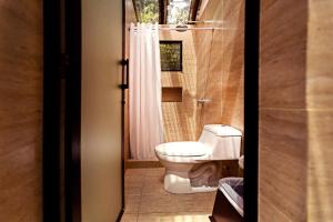 a bathroom with a toilet and a sink at Jungle Lodge Tikal Hostal in Tikal