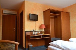 a hotel room with a bed and a tv on the wall at Gasthof Altes Rathaus garni in Rust