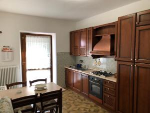 una cucina con armadi in legno, un tavolo e una sala da pranzo di Casa Pacini a Santa Fiora